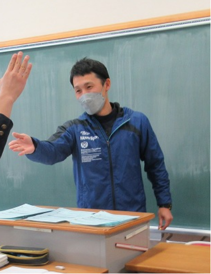 写真：黒板を背に生徒を指名する先生