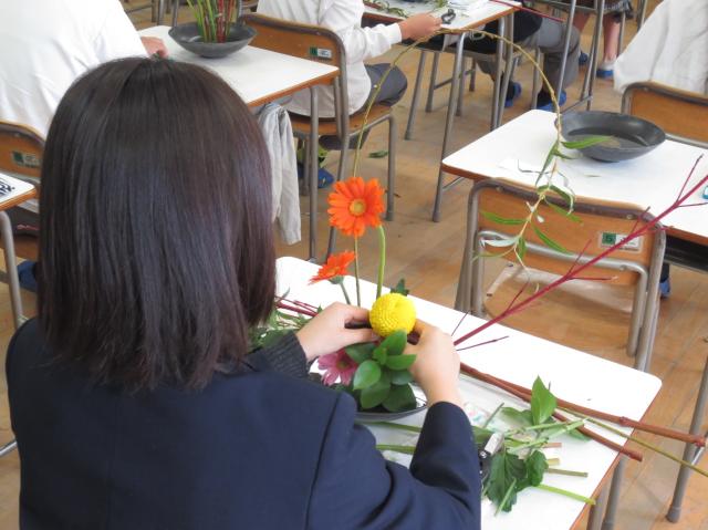 画像：花を生ける女子生徒の後ろ姿
