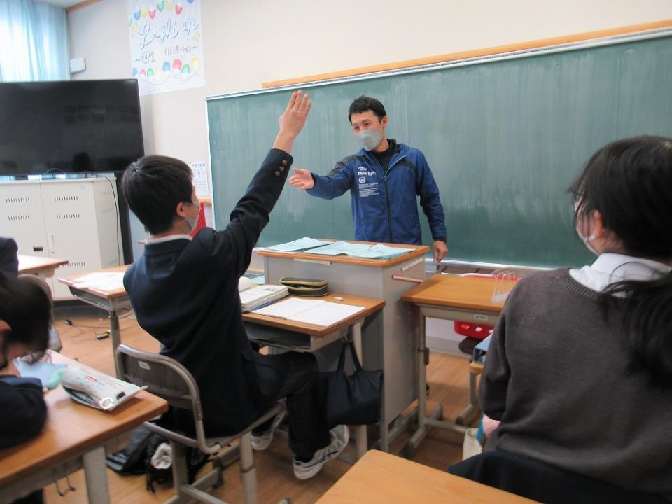 写真：教室で黒板を背に立つ教師が学生を指名する様子3