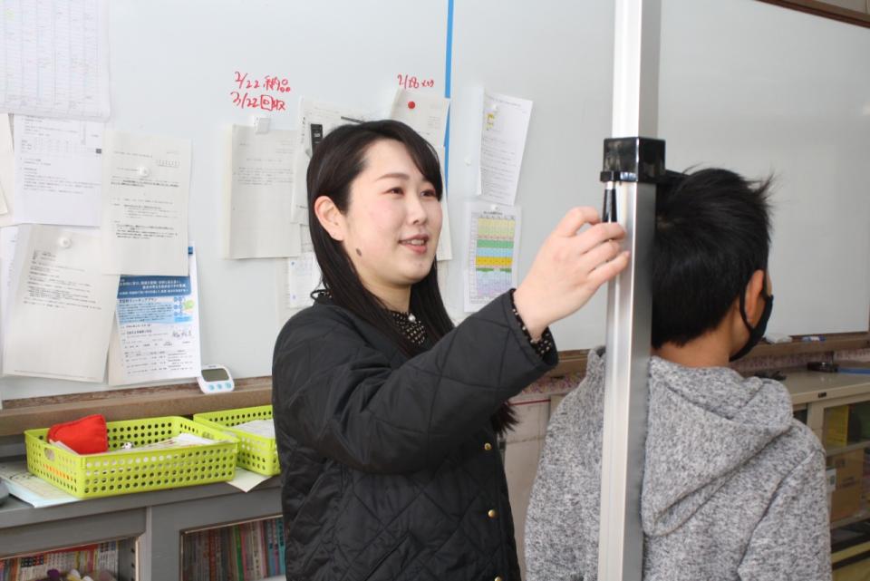 写真：保健室で生徒の伸長を測る先生3